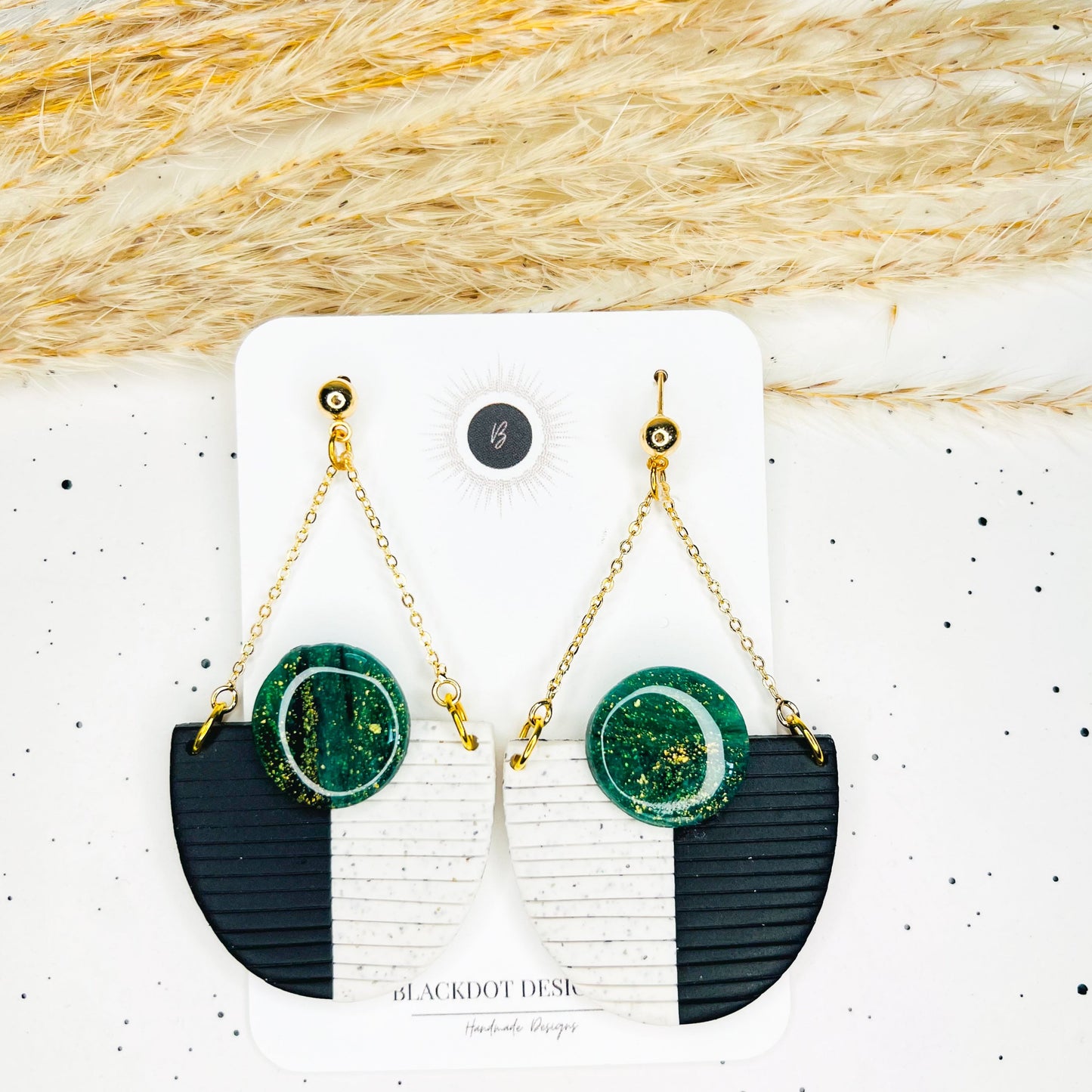 Black, green, and white earrings